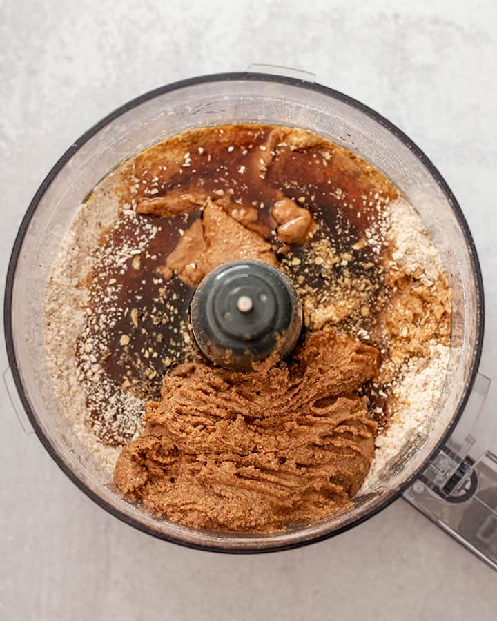Liquid ingredients being mixed with dry ingredients in a food processor.