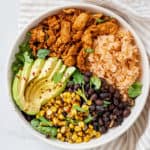 Fully assembled nourish bowl with Mexican rice, soy curls, black beans, fire roasted corn and avocado.