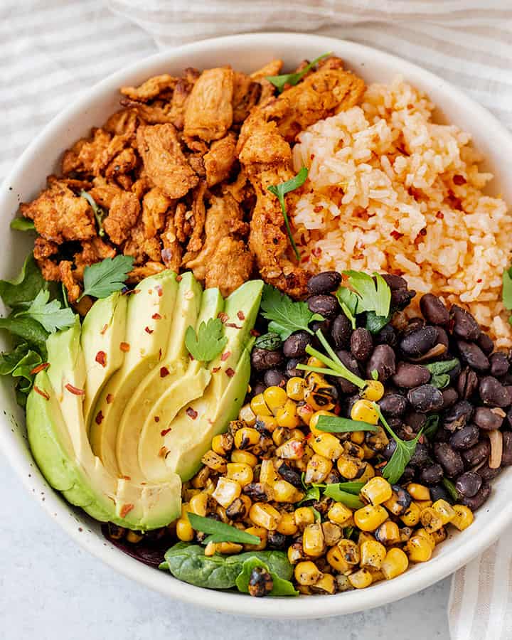 Fully assembled Latin Nourish bowl with avocado, soy curls, black beans, Mexican rice and corn.