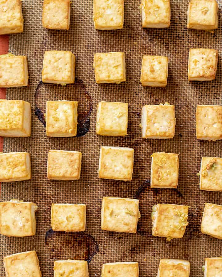 Sheet pan with baked tofu in rows.