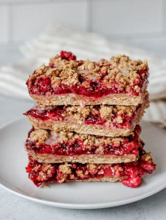 Stack of four crumble bars on a white plate.