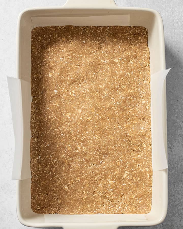 Oat base layer pressed into the baking tray.