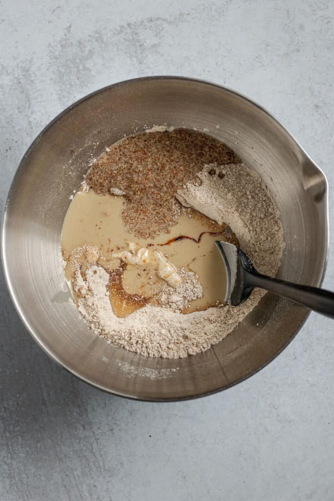 Metal mixing bowl with dry and wet cookie ingredients.