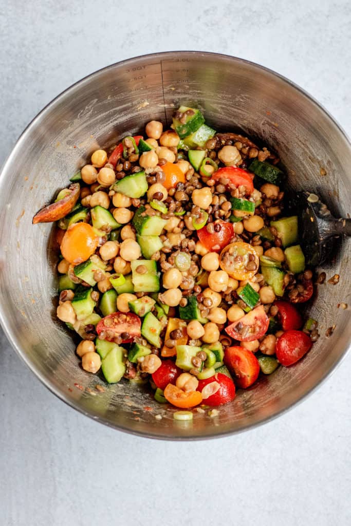 Mixing all the chickpeas, lentils, vegetables and dressing.