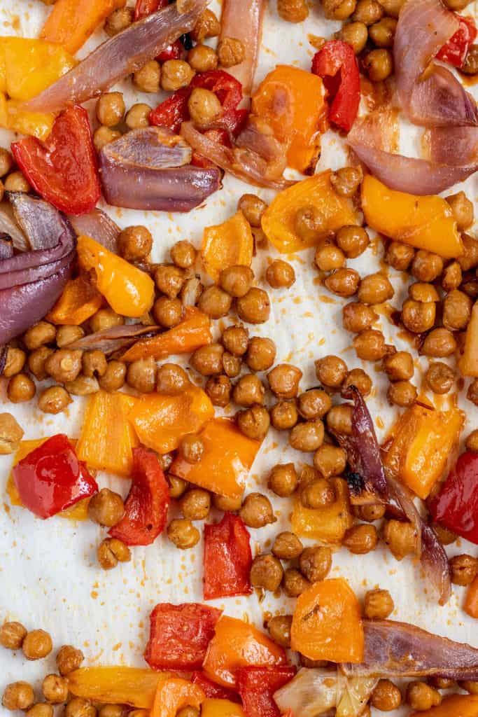 Chickpeas and vegetables coated in a sweet chili sauce after roasting in the oven on a sheet pan.