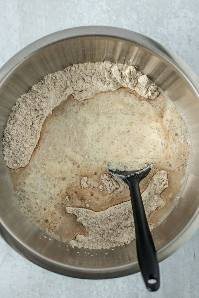 Adding the yeast mixture to the flour.