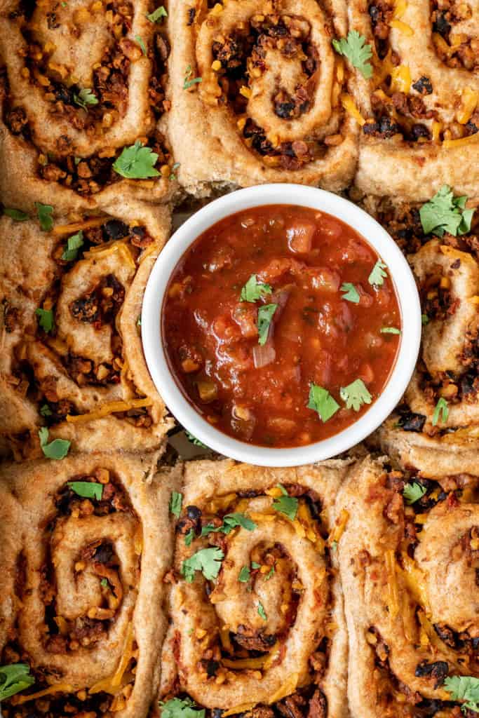 Close up of the taco pinwheels served with salsa.
