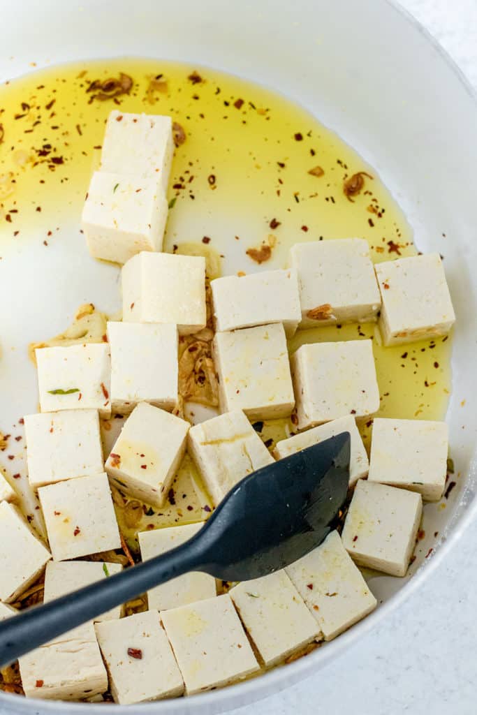 Tofu sautéing in oil, garlic and red pepper flakes in a large pot.