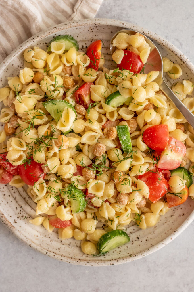 Creamy pasta salad being served with crispy chickpeas.