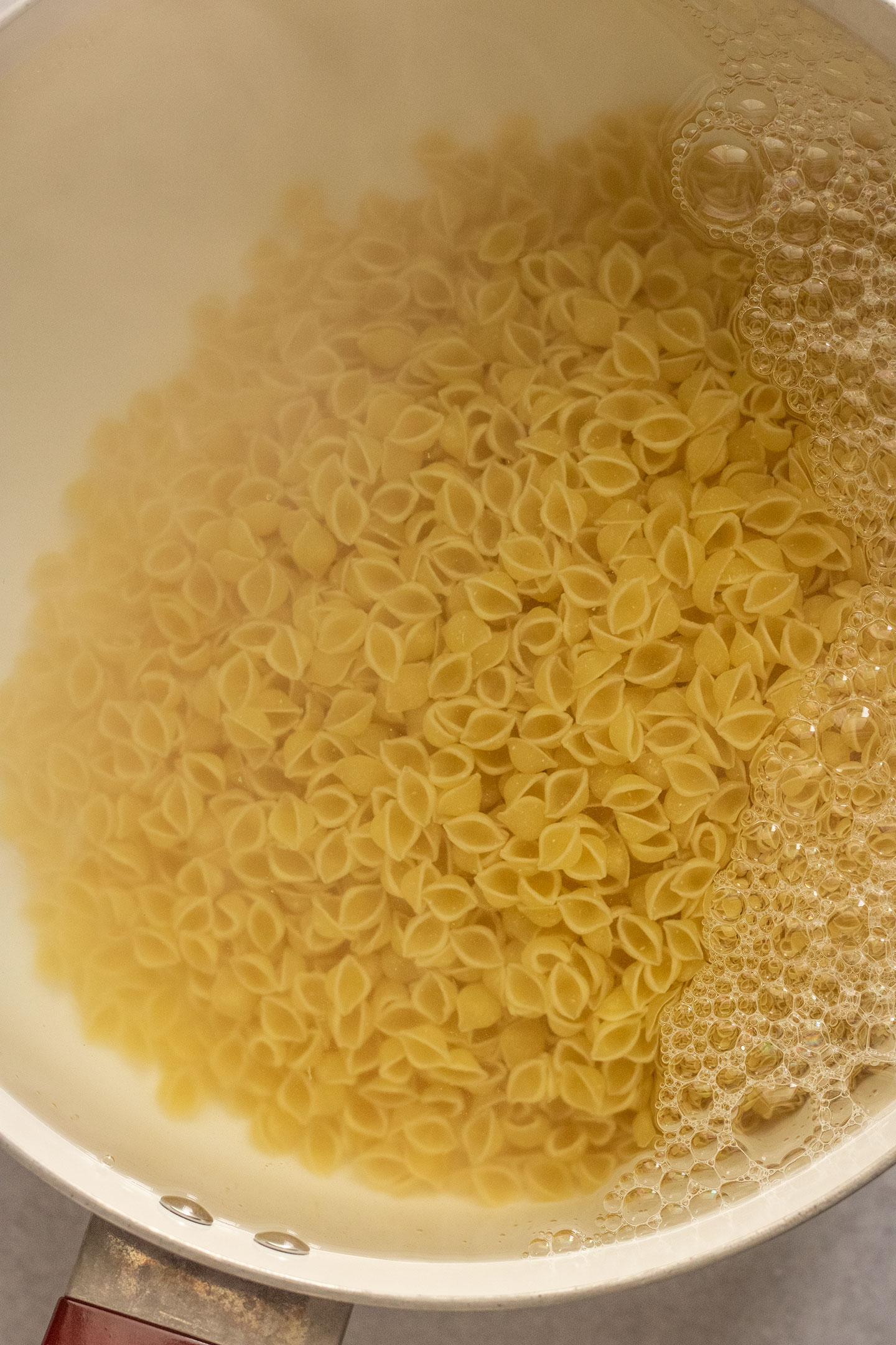 Pasta cooking in boiled salted water in a large pot.