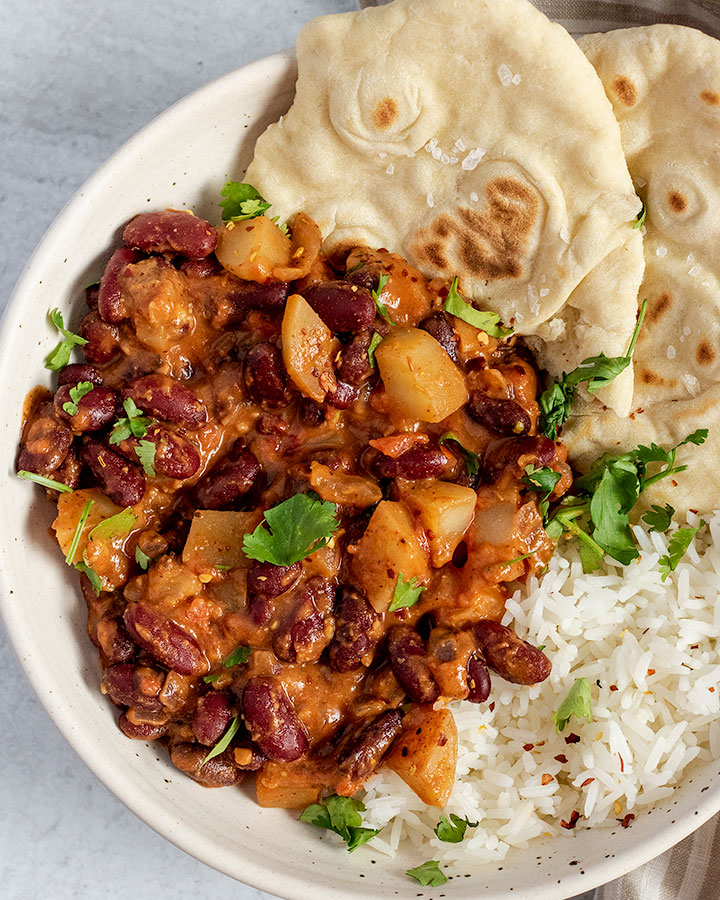 Close up of the skillet red beans served with naan and rice.