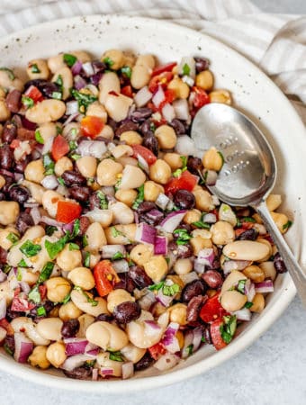 Close up of bean salad with a spoon tucked on the side.