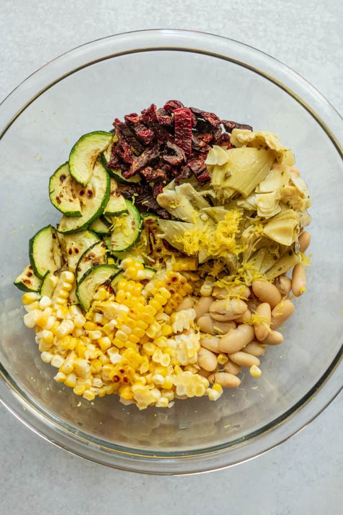 Bowl of corn, zucchini, artichoke hearts, sun-dried tomatoes and white beans.