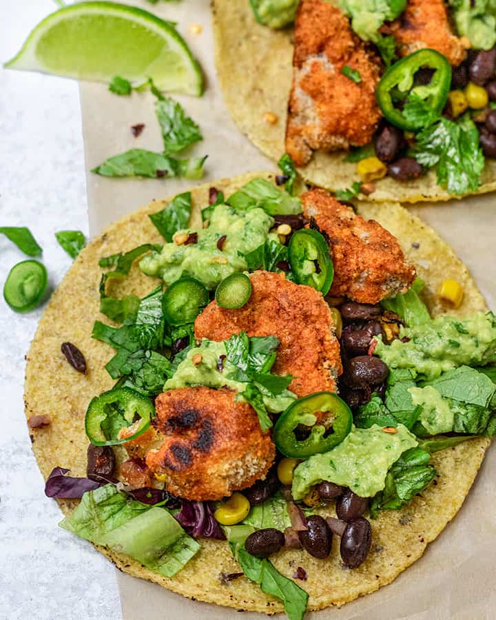 Close up of cauliflower taco topped with black beans, avocado, and jalapeno.