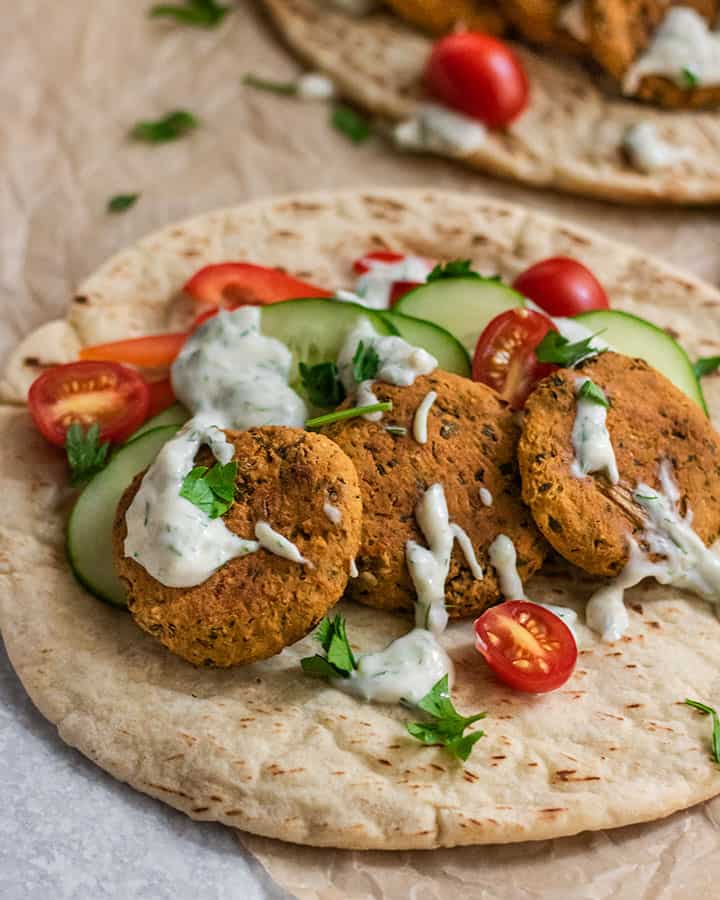 Chickpea patties served with extra vegetables and yogurt sauce.