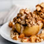 Plate of baked apples with caramel sauce on top.