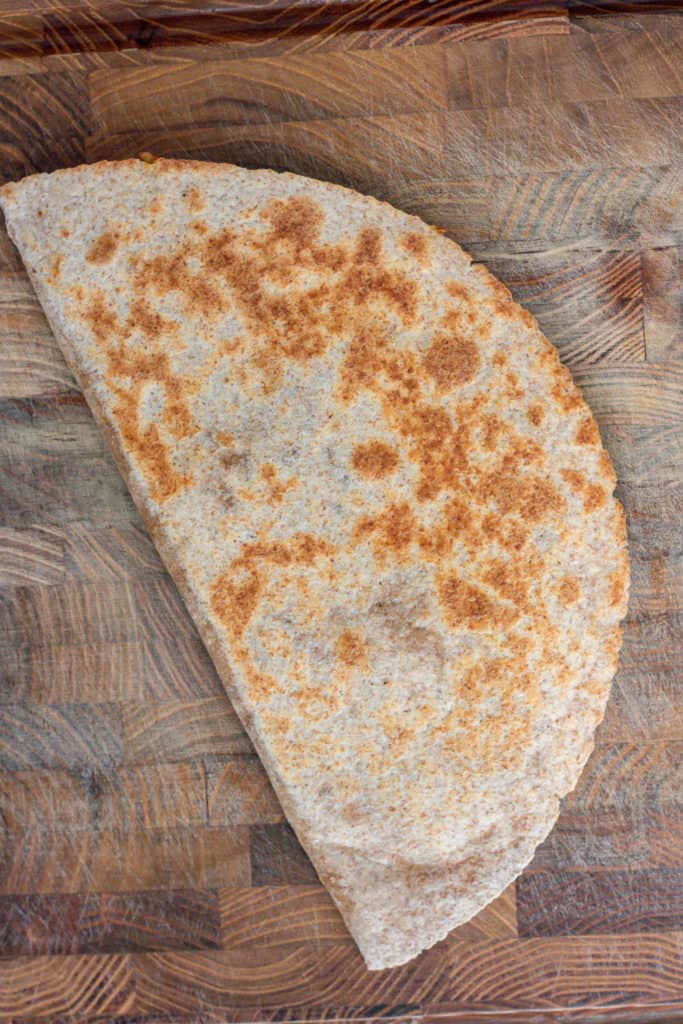 Quesadilla after being cooked on a skillet until browned.