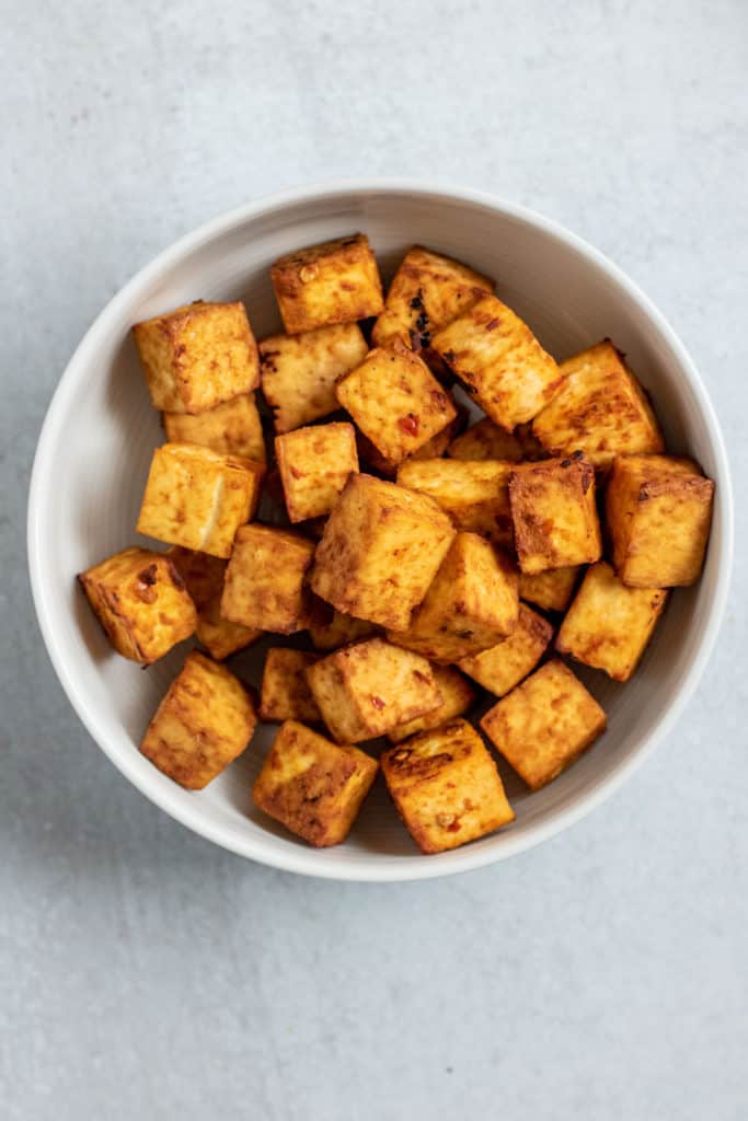 Fully baked tofu and placed in a white bowl.