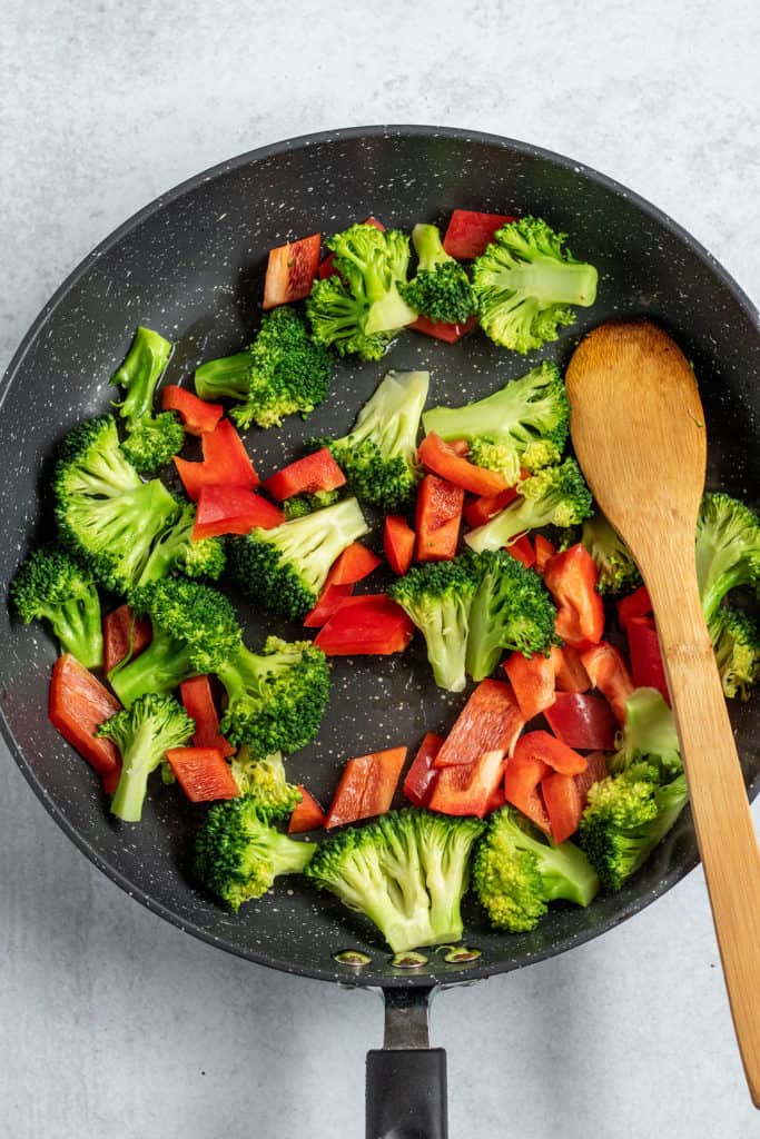 Sautéed broccoli and pepper in a sauce pan.