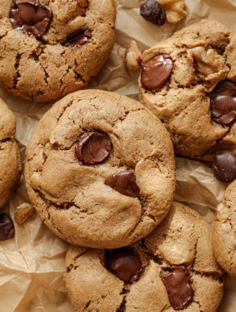 Close up of cookies piled together on parchment paper.