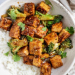 Top down shot of the stir fry tofu topped with fresh cilantro and served with white rice.