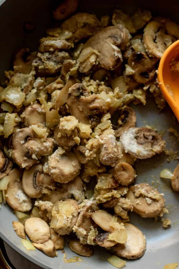 Mushrooms dusted in flour and sautéing in a pan.