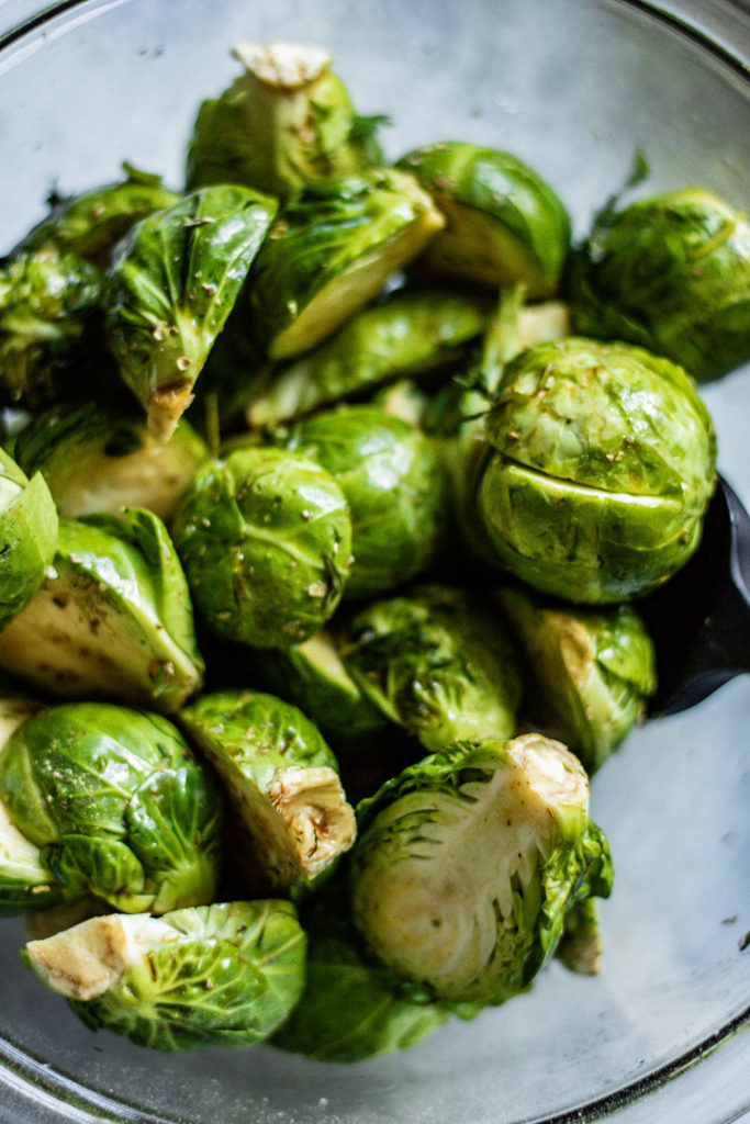 Bowl of brussels sprouts coated in marinade.