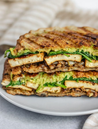 Close up of the inside of a vegan panini sandwich filled with tofu, avocado and avocado.