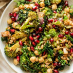 Salad bowl of farro, roasted broccoli, pomegranate and pepitas.