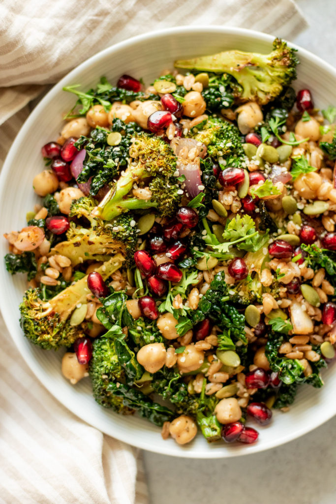Close up of bowl of farro with kale, pomegranate and pepitas.