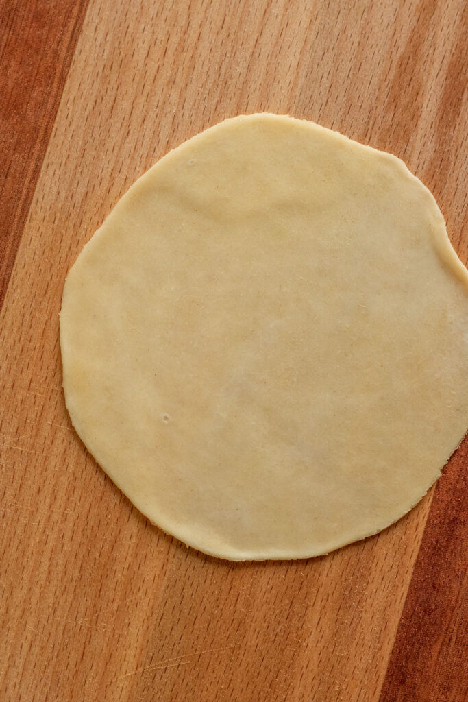 Dough rolled thin on a flat surface.