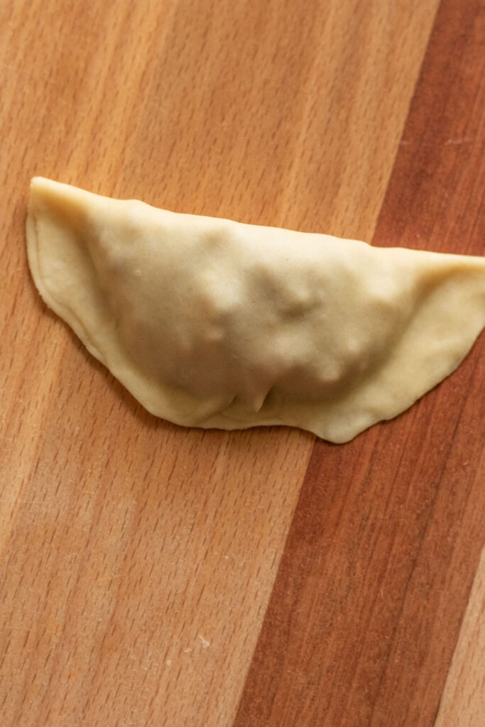 Dough folded over tempeh filling and pinched sealed.