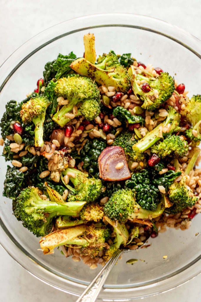 Mixed bowl of roasted vegetables, kale, chickpeas, pomegranate and pepitas.