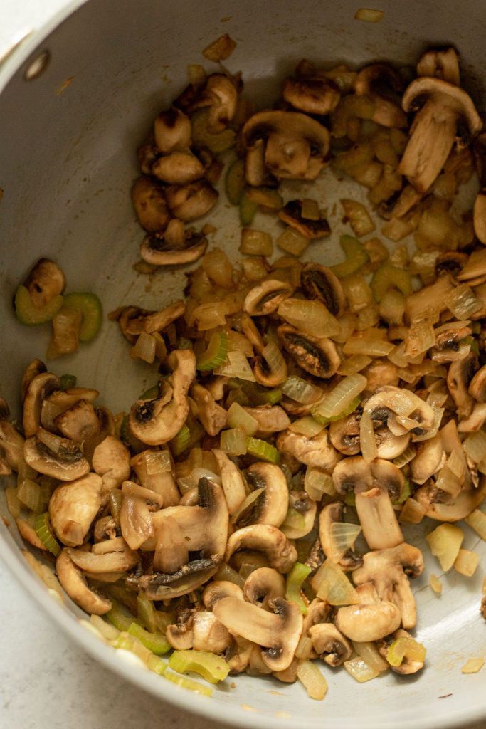 Mushrooms, onions and garlic sautéed together in a pot.