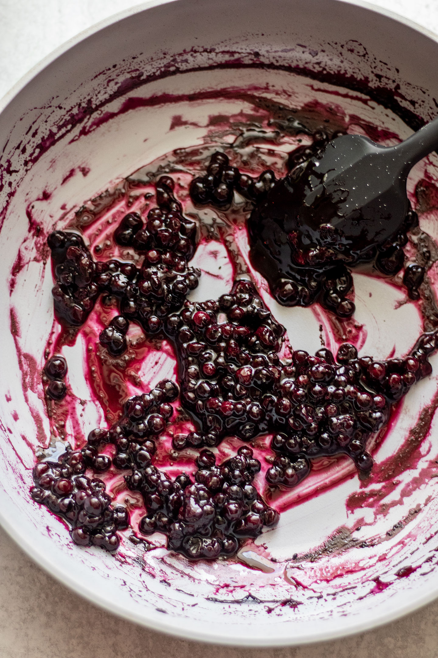 Blueberries thickening and cooking on a sauce pan.