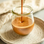 Pouring dressing into a small jar.