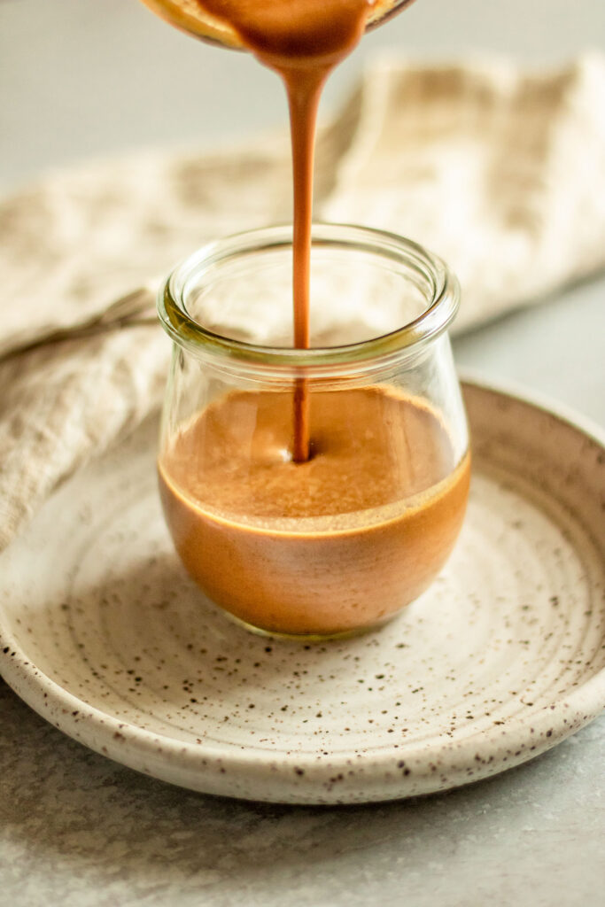 Pouring dressing into a small jar.