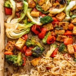Sheet pan of coated tofu, vegetables and noodles in a maple soy glaze.
