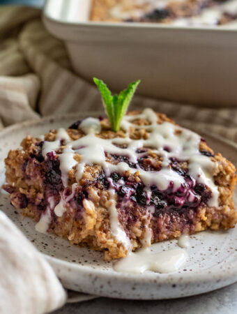 Slice of baked oatmeal with blueberry jam in the center.