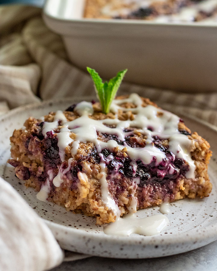 Slice of baked oatmeal with blueberry jam in the center.