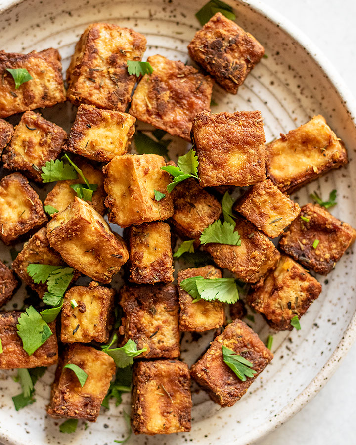 Close up view of baked tofu topped with cilantro.