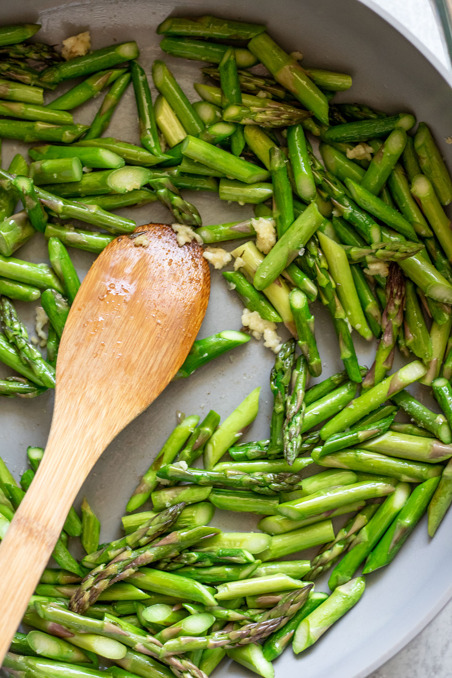 Sautéing asparagus and garlic in a pan.