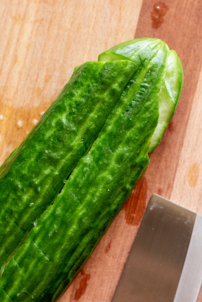 Smashed cucumber on a cutting board.