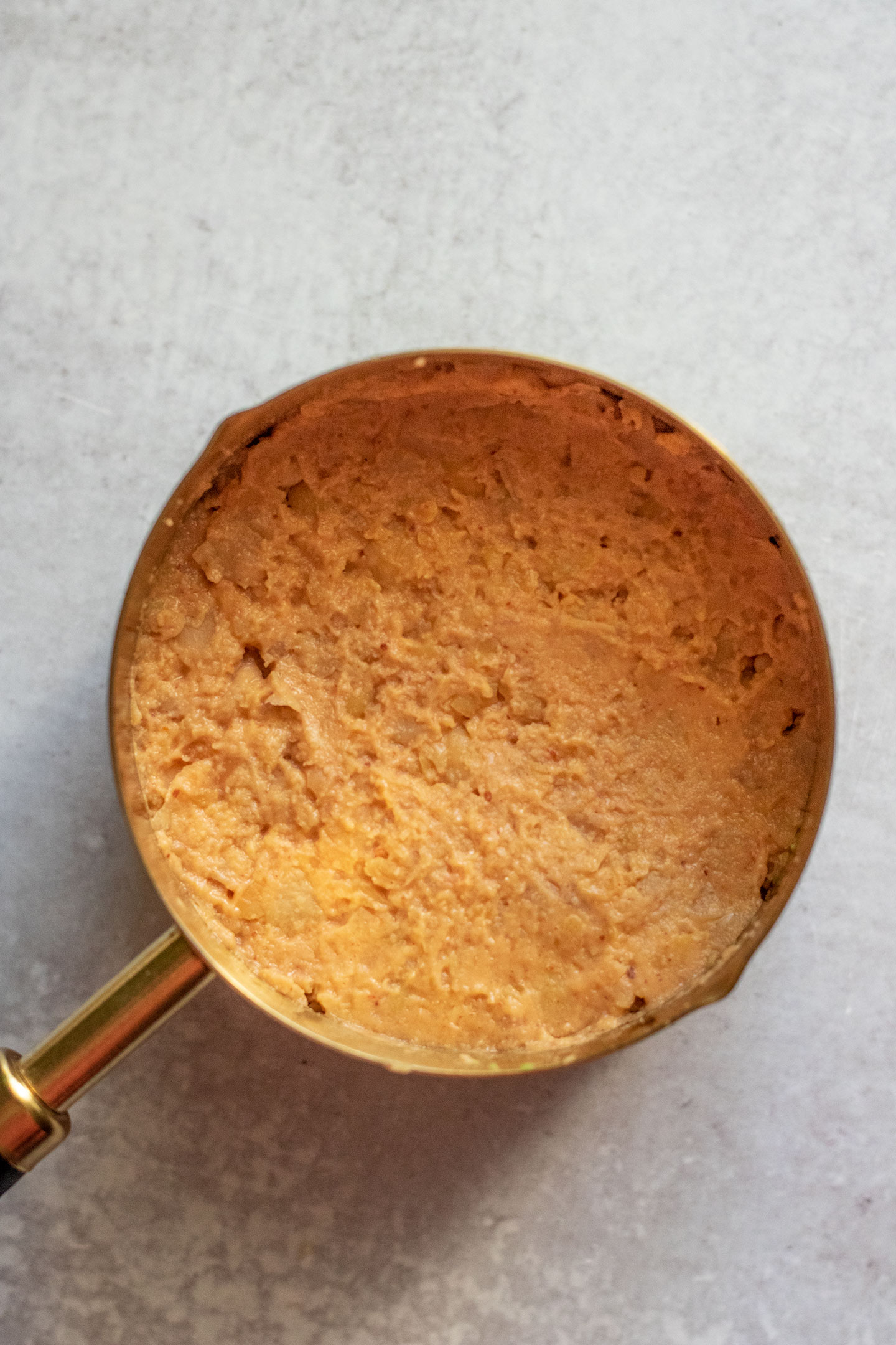 Adding a layer of mashed peanut miso chickpeas into the cup on top of the avocado.