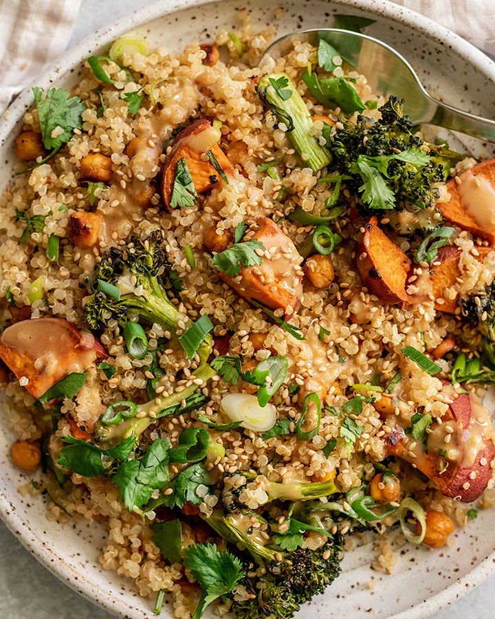 Plate of roasted sweet potato quinoa salad topped with sesame miso dressing and cilantro.