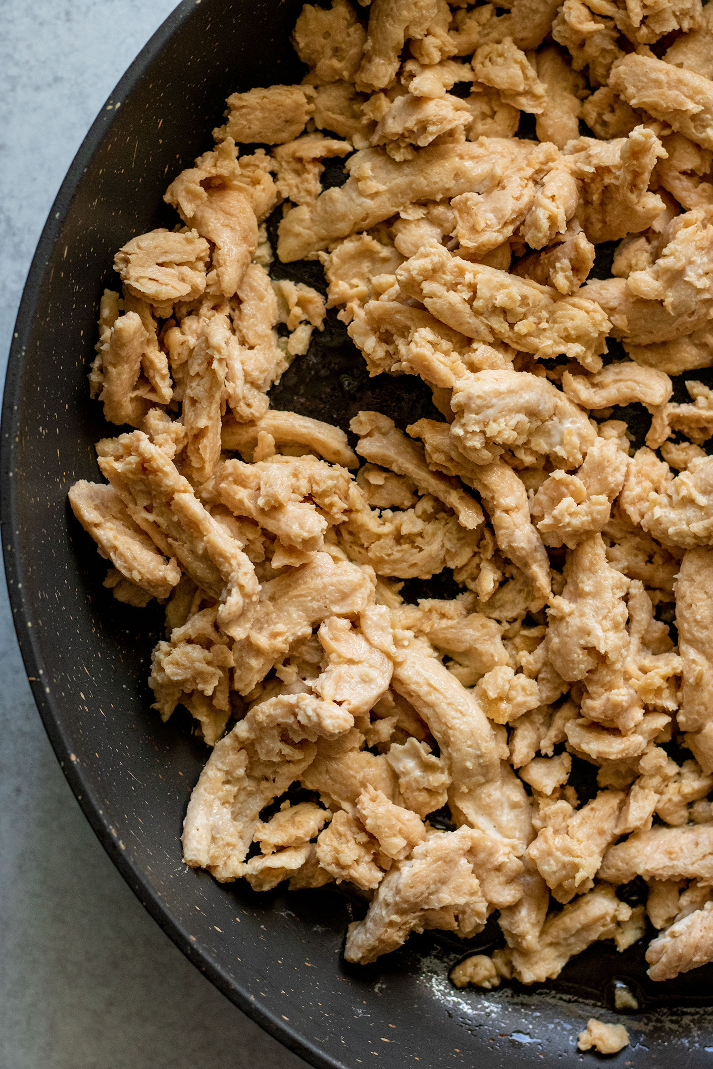 Adding the rehydrated soy curls to a pan with oil to crisp up.