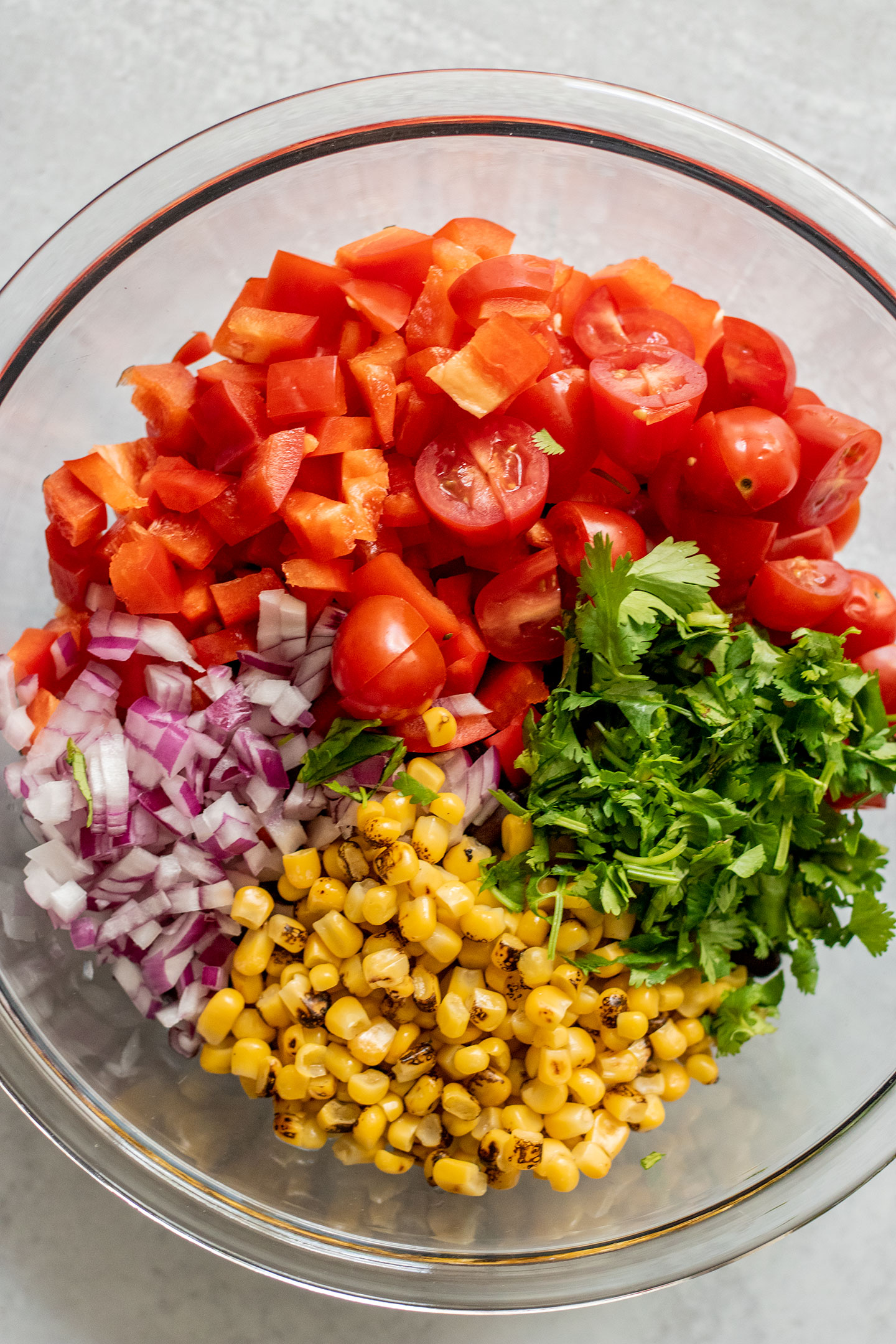 Bowl of black beans, chopped tomatoes, bell pepper, red onion, fire roasted corn and cilantro.