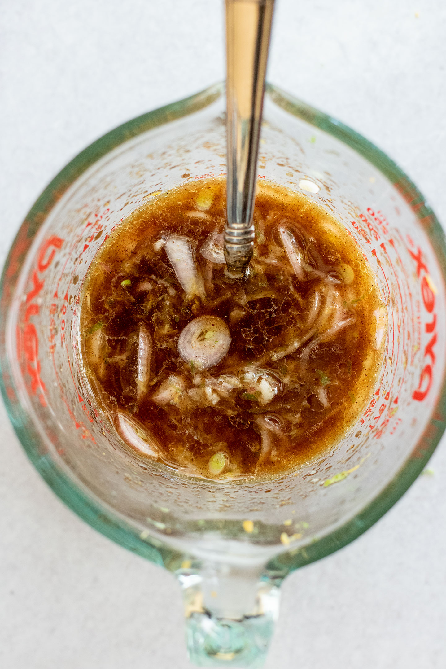 Mixing the citrus juices together with oil, vinegar, maple syrup, shallots and garlic.