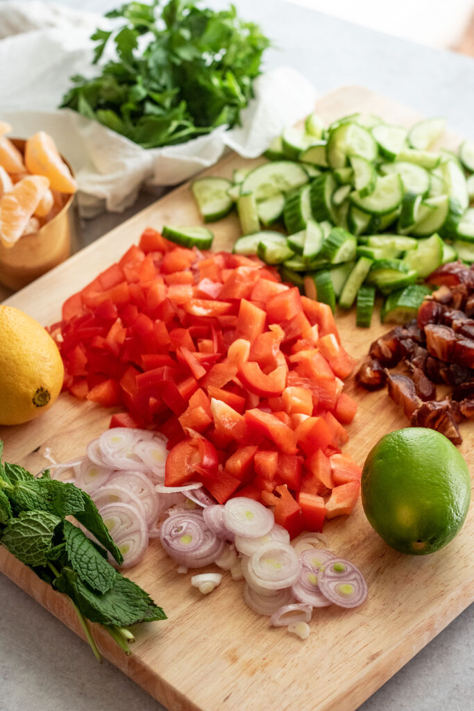 Diced peppers, cucumbers, date, mint, parsley, mandarin oranges, chickpeas, and shallots.