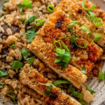 Close up of crispy panko crusted tofu topped with chili oil and scallions.